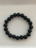 a black bead shungite crystal bracelet against a white background