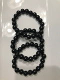 three black bead shungite crystal bracelets against a white background