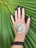 three garnet faceted crystal stretch bracelets on a woman's arm with black nails and a gold press on tattoo on her hand against a green palm leaf