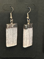 selenite earrings on a black background