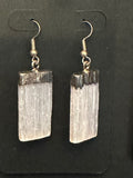 selenite earrings on a black background