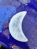 selenite crescent moon dish against blue background