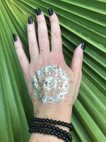 three 4 mm bead black tourmaline crystal stretch bracelets on a woman's arm with a gold press on tattoo with black nails against a green palm leaf