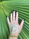 6 mm bead light green peridot crystal stretch bracelet on a woman's arm with a gold press on tattoo with black nails against a green palm leaf