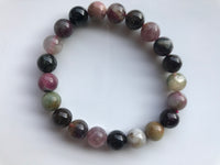 large bead size mixed tourmaline - purple pink gray green beads against a white background