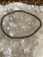 pyrite crystal stretch bracelet on a white apophyllite crystal