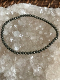 pyrite crystal stretch bracelet on a white apophyllite crystal