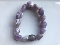 a light purple white and gray tumbled bead amethyst crystal bracelet on a white background