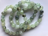 a set of 3 tumbled prehnite crystal stretch bracelets against a white background